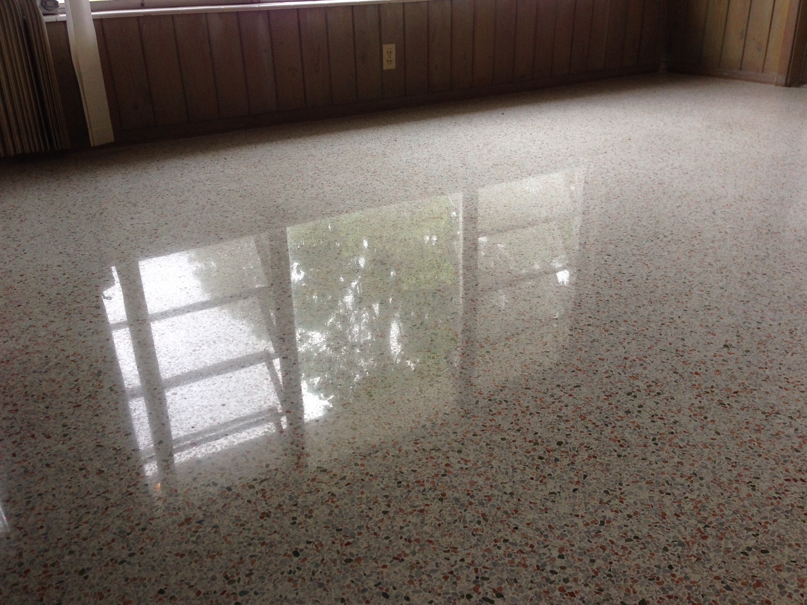 Polished terrazzo in a living room with wood panel walls