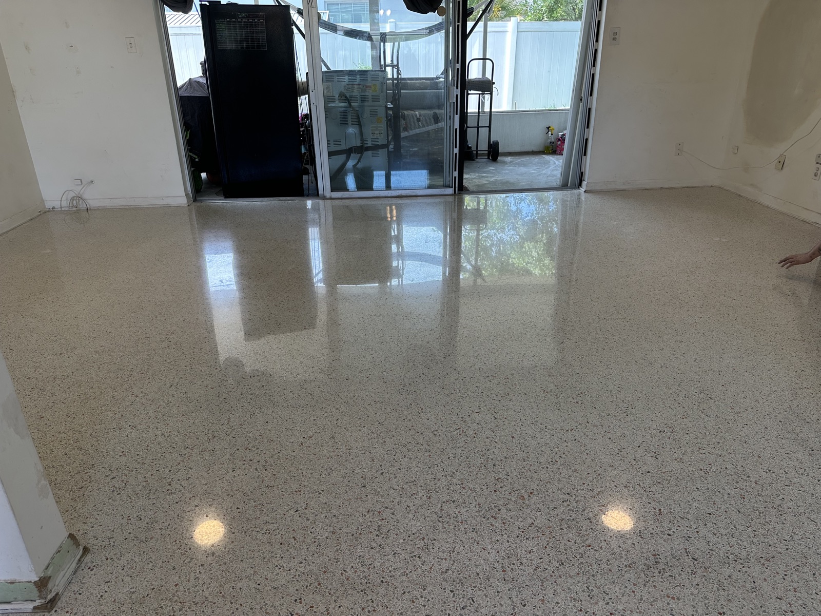 The same living room after restoration and polishing, looking toward the sliding doors