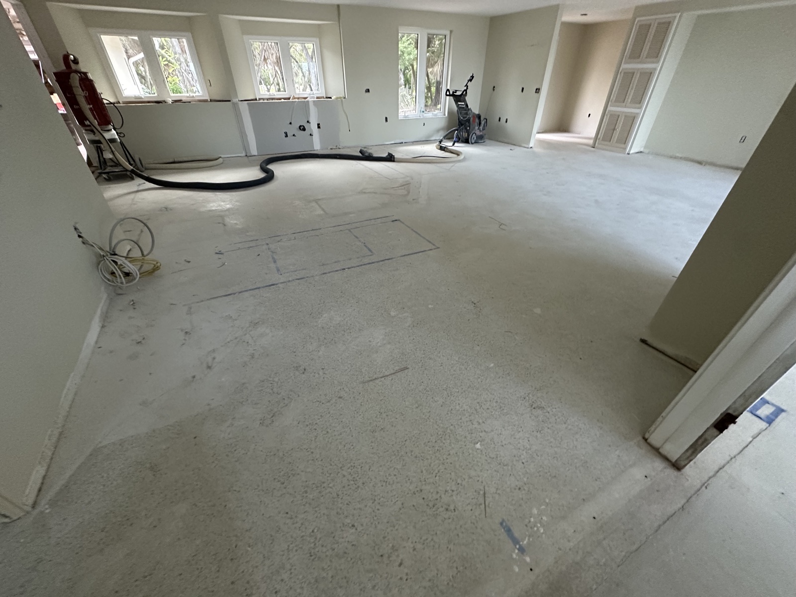 Main room before resurfacing, with the grinder and dust vacuum set up