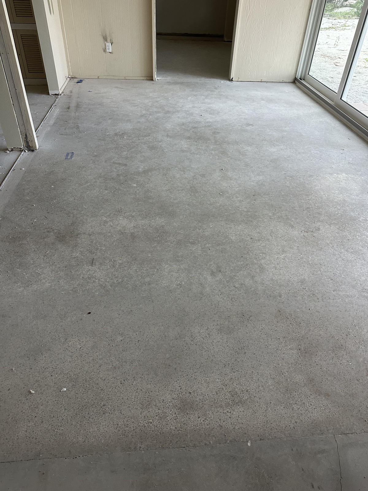 Sunroom terrazzo before resurfacing, dull gray with stains across the floor