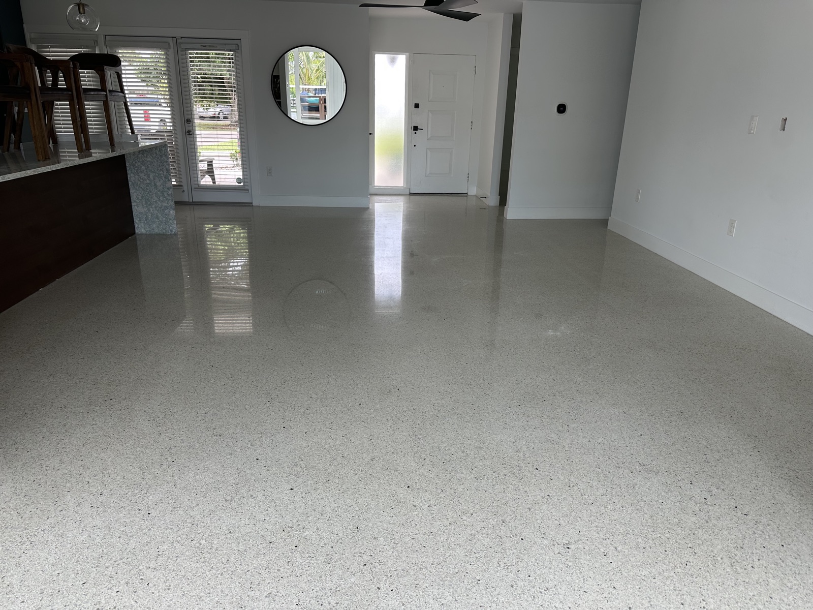 Polished terrazzo looking toward the front door, with the kitchen island on the left