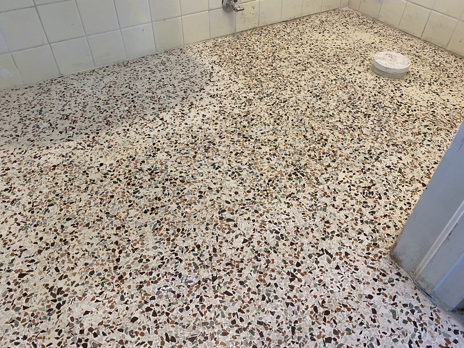 A finished floor showing a trench that was patched after plumbing work was done.